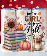 Load image into Gallery viewer, Three white insulated tumblers with clear lids are shown side by side on a white surface against a red bokeh background. The tumblers feature fall-themed printed designs: a sunflower and stacked books on the left, the phrase 'just a GIRL who loves Fall' with small hearts in the middle, and a hot coffee cup with whipped cream on the right.
